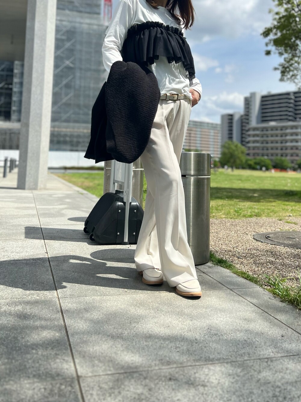 ホワイト系のその他パンツ、ホワイト系のローファー、ブラック系のカーディガン/ボレロを着用したレディースの春コーディネートの4枚目の写真
