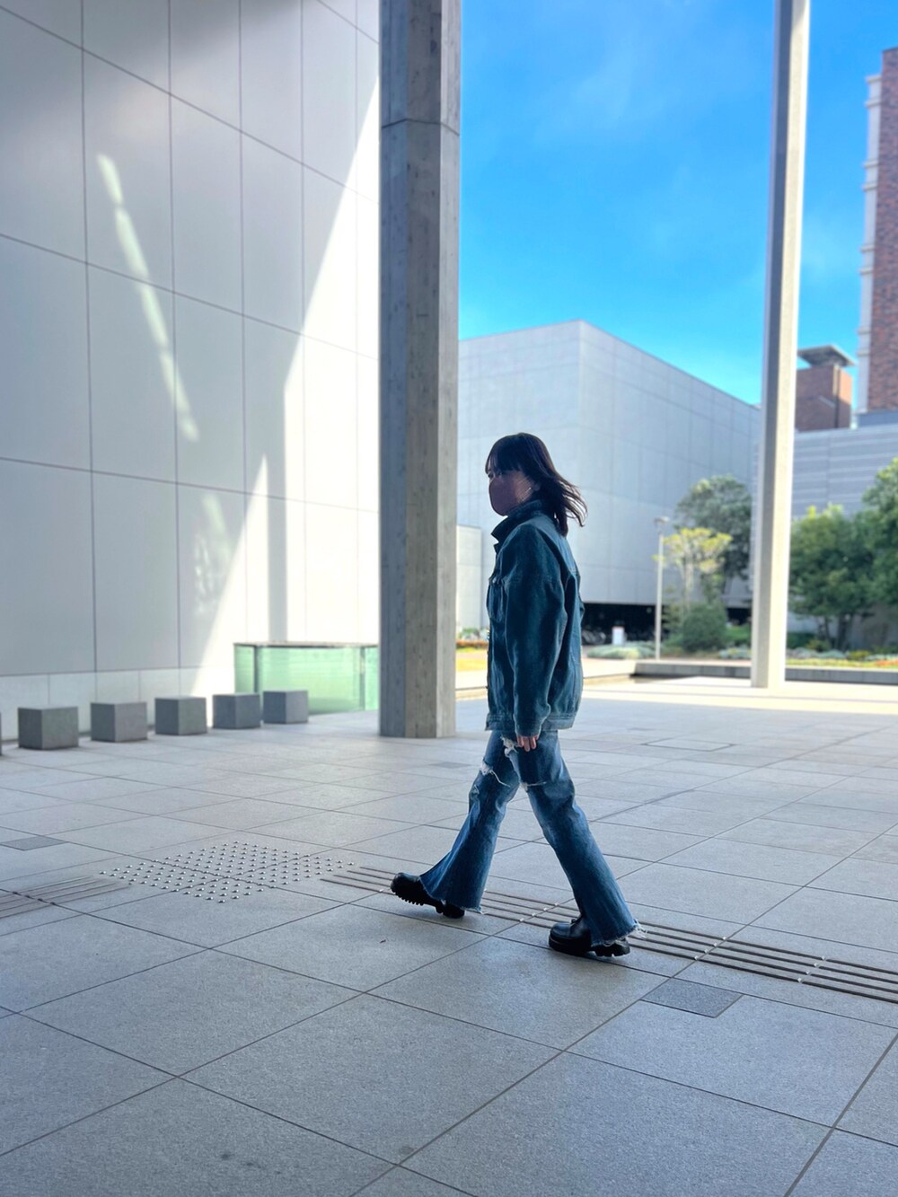 ホワイト系のカーディガン/ボレロ、ブルー系のデニムパンツ、ブラック系のブーツを着用したレディースの冬コーディネートの3枚目の写真