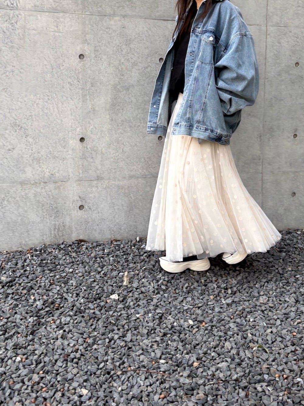 ブルー系のデニムジャケット、ブラック系のTシャツ/カットソー、ホワイト系のスカートを着用したレディースの春コーディネートの2枚目の写真