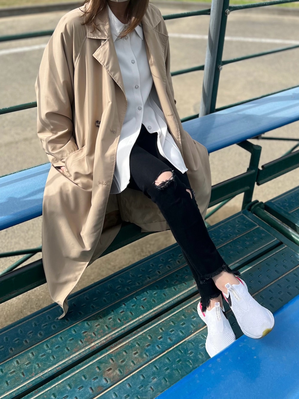 ベージュ系のトレンチコート、ホワイト系のシャツ/ブラウス、ブラック系のデニムパンツを着用したレディースの春コーディネートの2枚目の写真