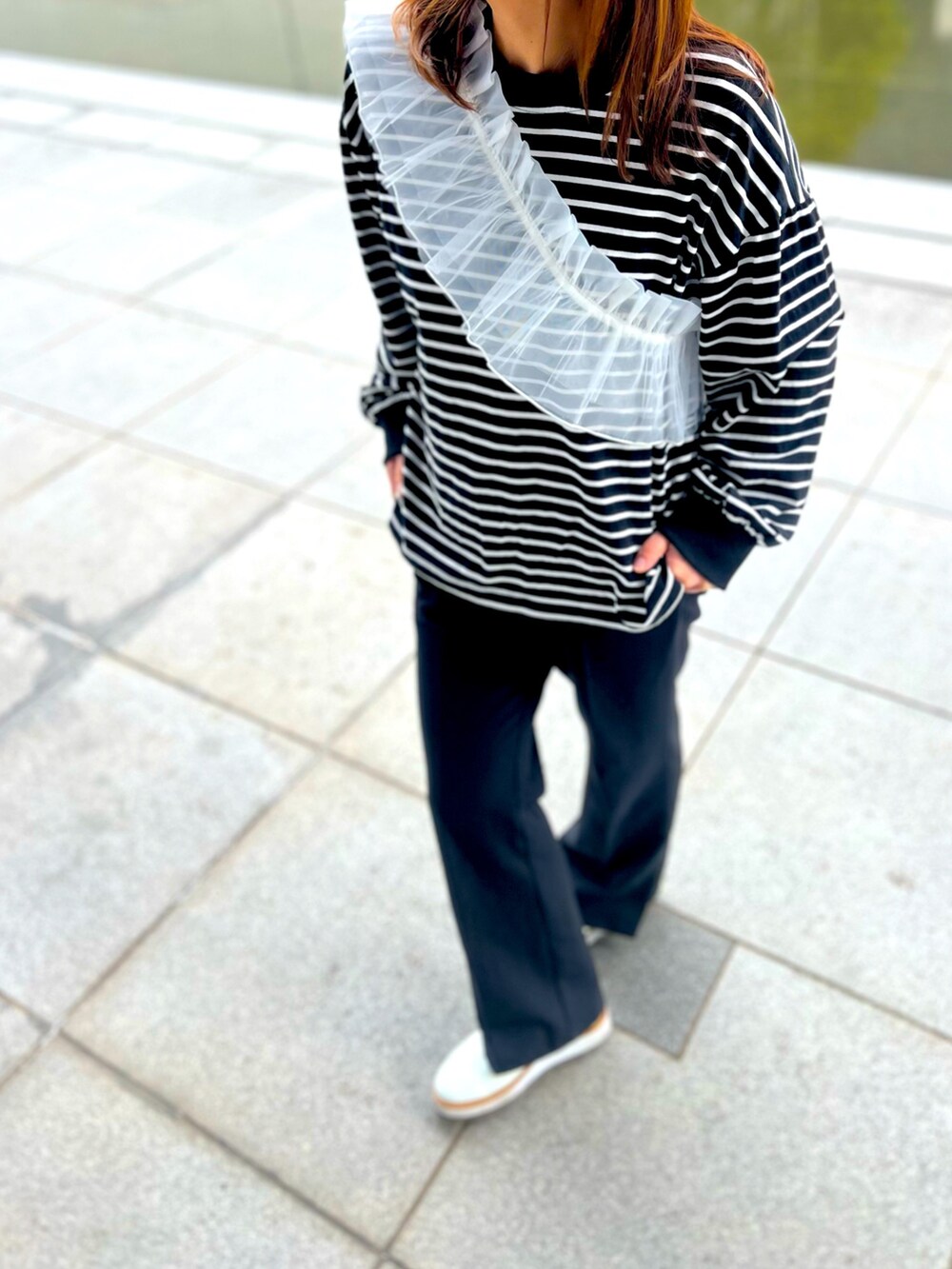 ブラック系のTシャツ/カットソー、ブラック系のその他パンツ、ホワイト系のローファーを着用したレディースの春コーディネートの2枚目の写真