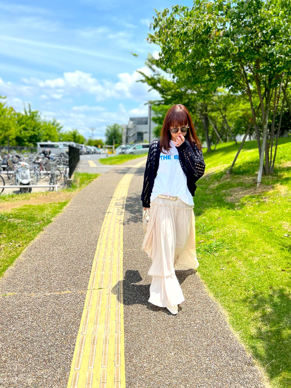 ホワイト系のTシャツ/カットソー、ブラック系のカーディガン/ボレロ、ホワイト系のショルダーバッグを着用したレディースの春コーディネートの3枚目の写真