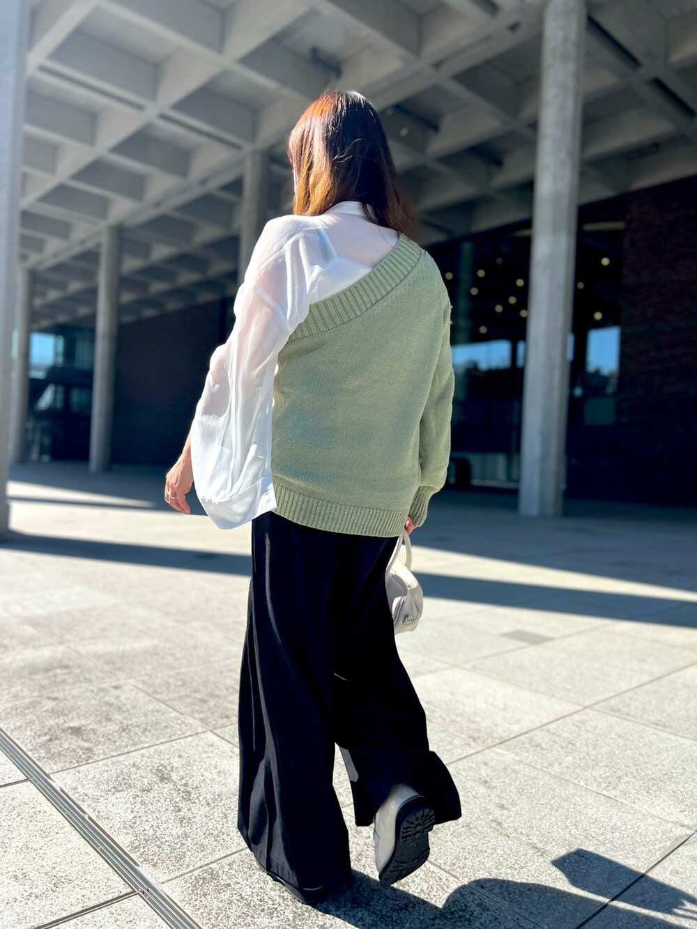 ホワイト系のシャツ/ブラウス、ホワイト系のショルダーバッグ、ホワイト系のローファーを着用したレディースの秋コーディネートの4枚目の写真