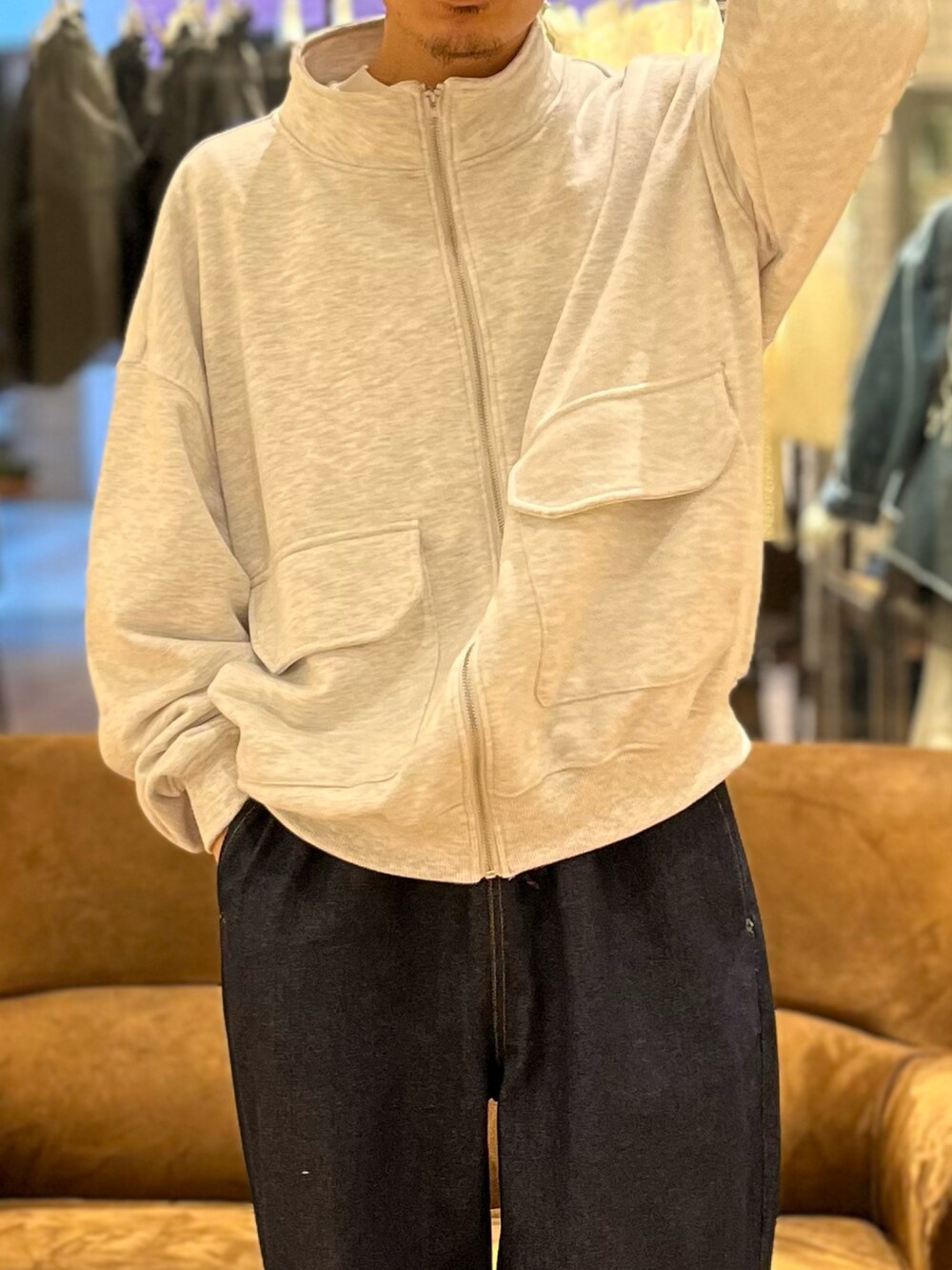 グレー系のブルゾン、ブルー系のデニムパンツ、ブラック系のスニーカーを着用したメンズの春コーディネートの2枚目の写真