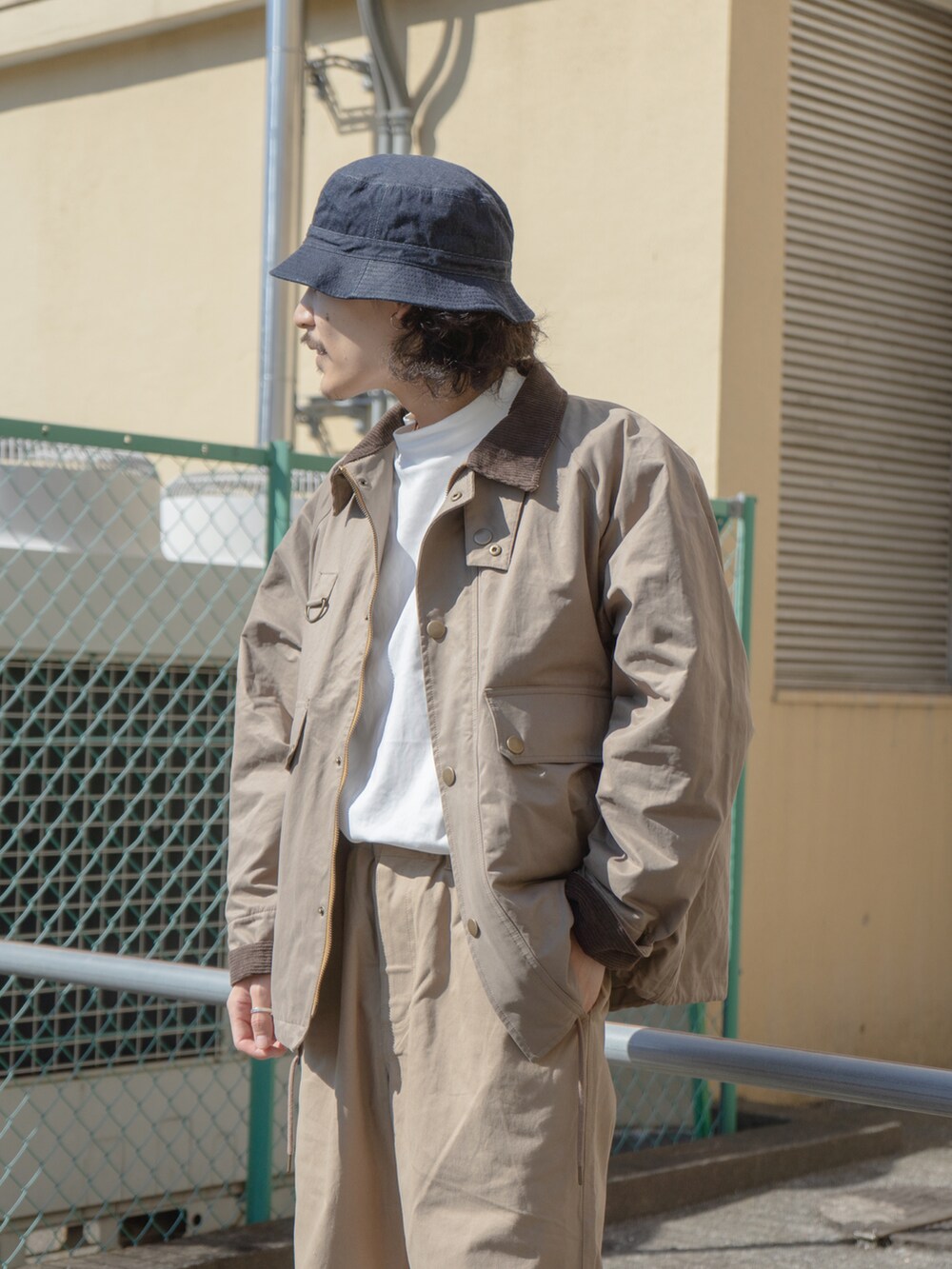ベージュ系のその他パンツ、ベージュ系のブルゾン、ホワイト系のTシャツ/カットソーを着用したメンズの秋コーディネートの2枚目の写真