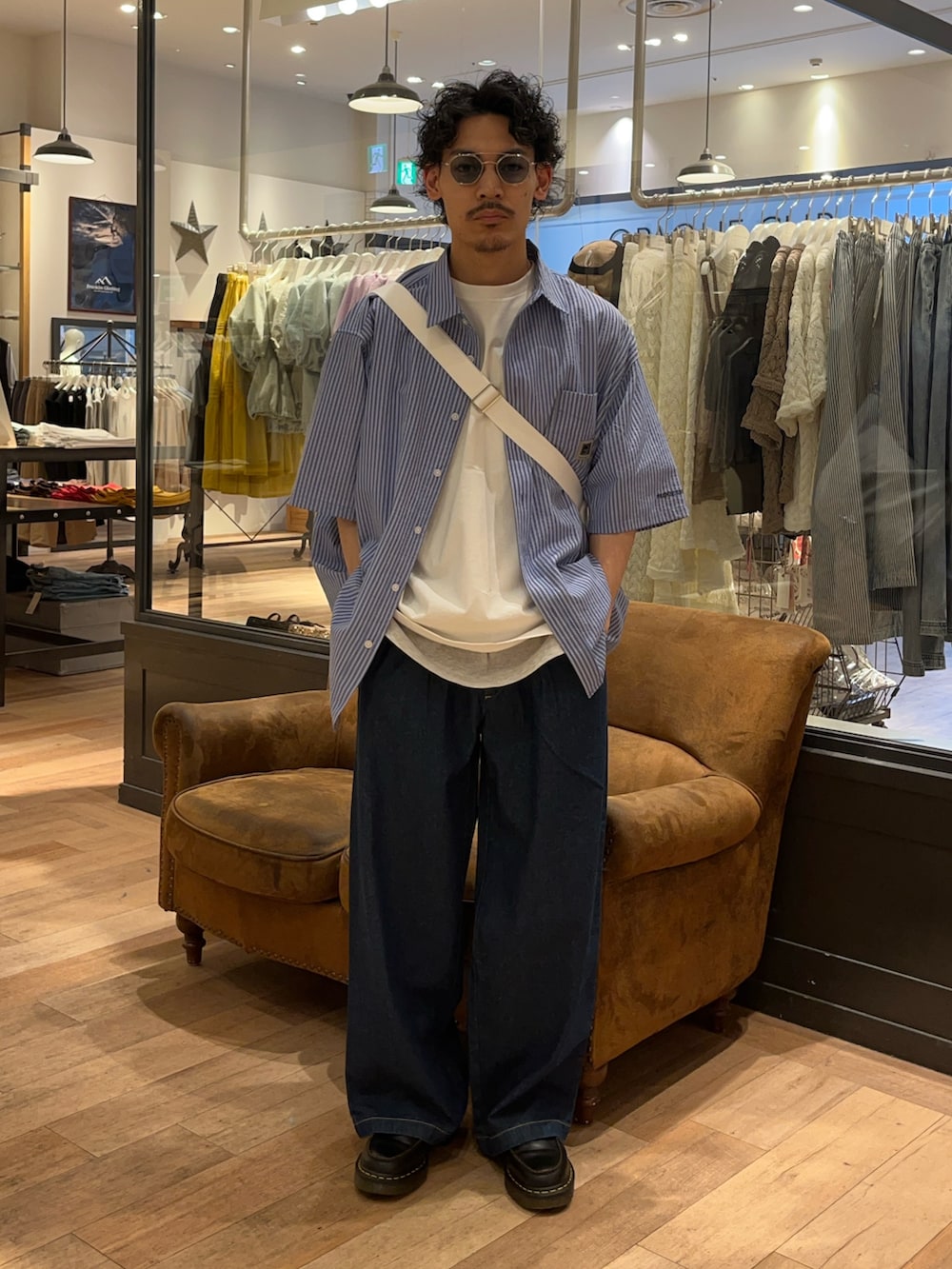 ブルー系のシャツ/ブラウス、ブルー系のデニムパンツ、ホワイト系のショルダーバッグを着用したメンズの夏コーディネートの2枚目の写真