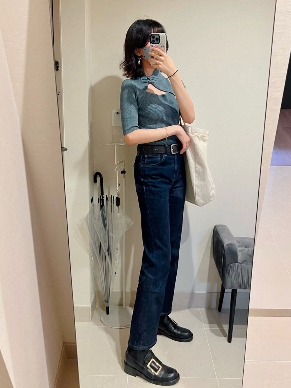 ブルー系のニット/セーター、ベージュ系のエコバッグ/サブバッグ、ブルー系のデニムパンツを着用したレディースの夏コーディネートの2枚目の写真