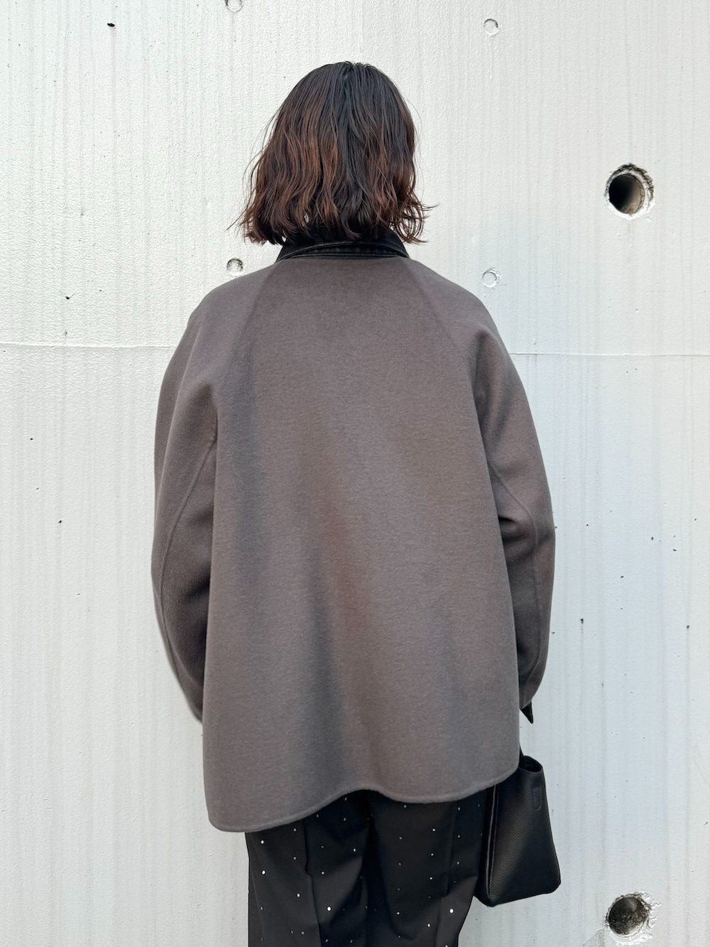グレー系のノーカラーコート、ブラック系のその他パンツ、グレー系のニット/セーターを着用したレディースの秋コーディネートの7枚目の写真