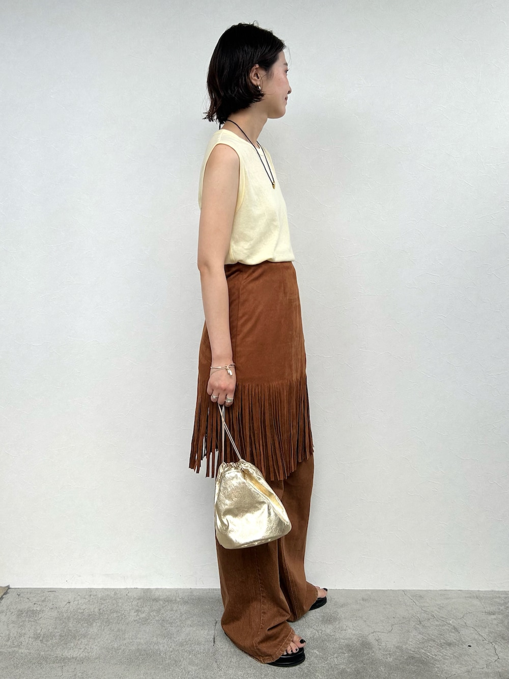 ブラウン系のスカート、イエロー系のトップス、ブラウン系のその他パンツを着用したレディースの夏コーディネートの2枚目の写真