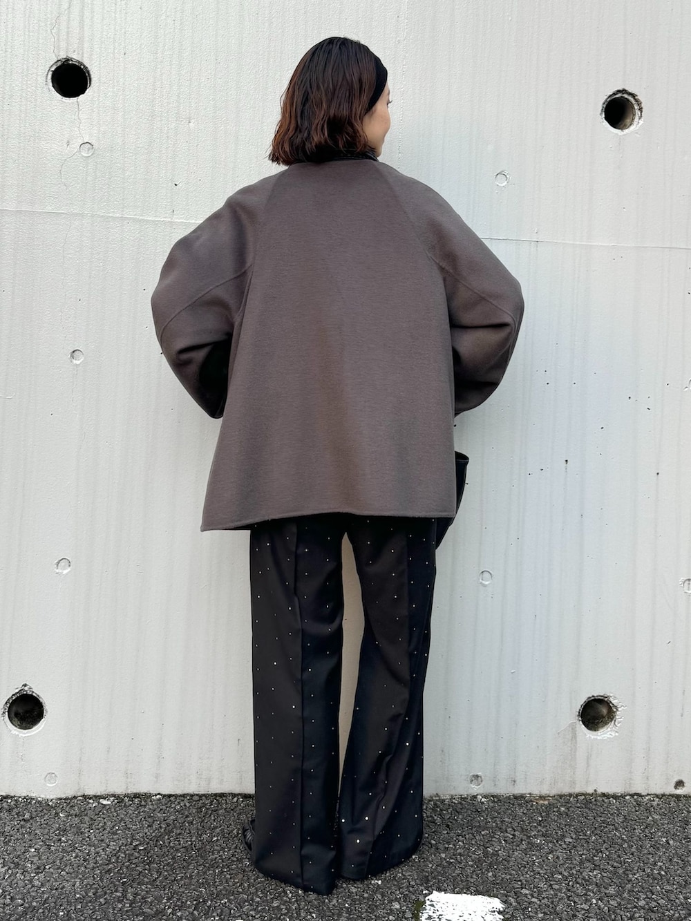 グレー系のノーカラーコート、ブラック系のその他パンツ、グレー系のニット/セーターを着用したレディースの秋コーディネートの3枚目の写真