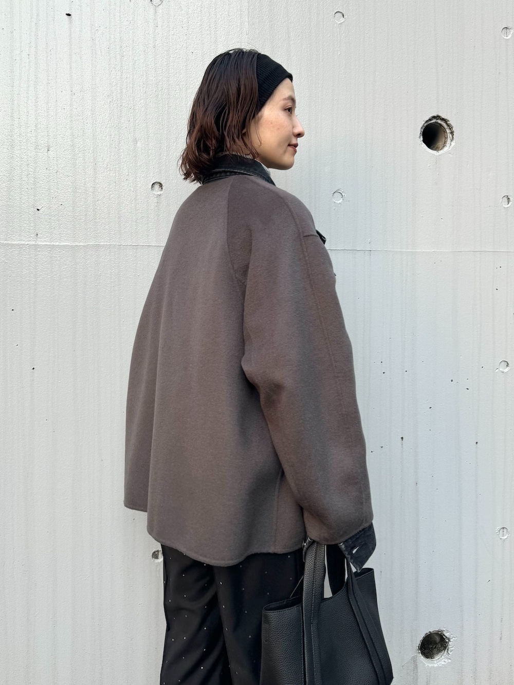 グレー系のノーカラーコート、ブラック系のその他パンツ、グレー系のニット/セーターを着用したレディースの秋コーディネートの6枚目の写真