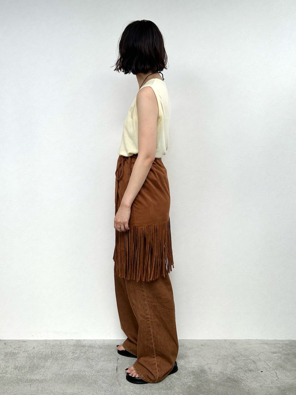 ブラウン系のスカート、イエロー系のトップス、ブラウン系のその他パンツを着用したレディースの夏コーディネートの3枚目の写真