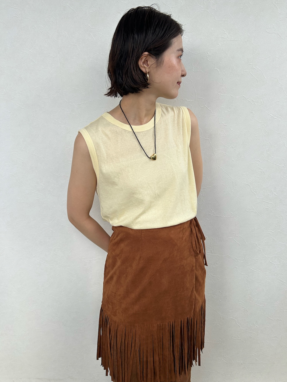 ブラウン系のスカート、イエロー系のトップス、ブラウン系のその他パンツを着用したレディースの夏コーディネートの5枚目の写真