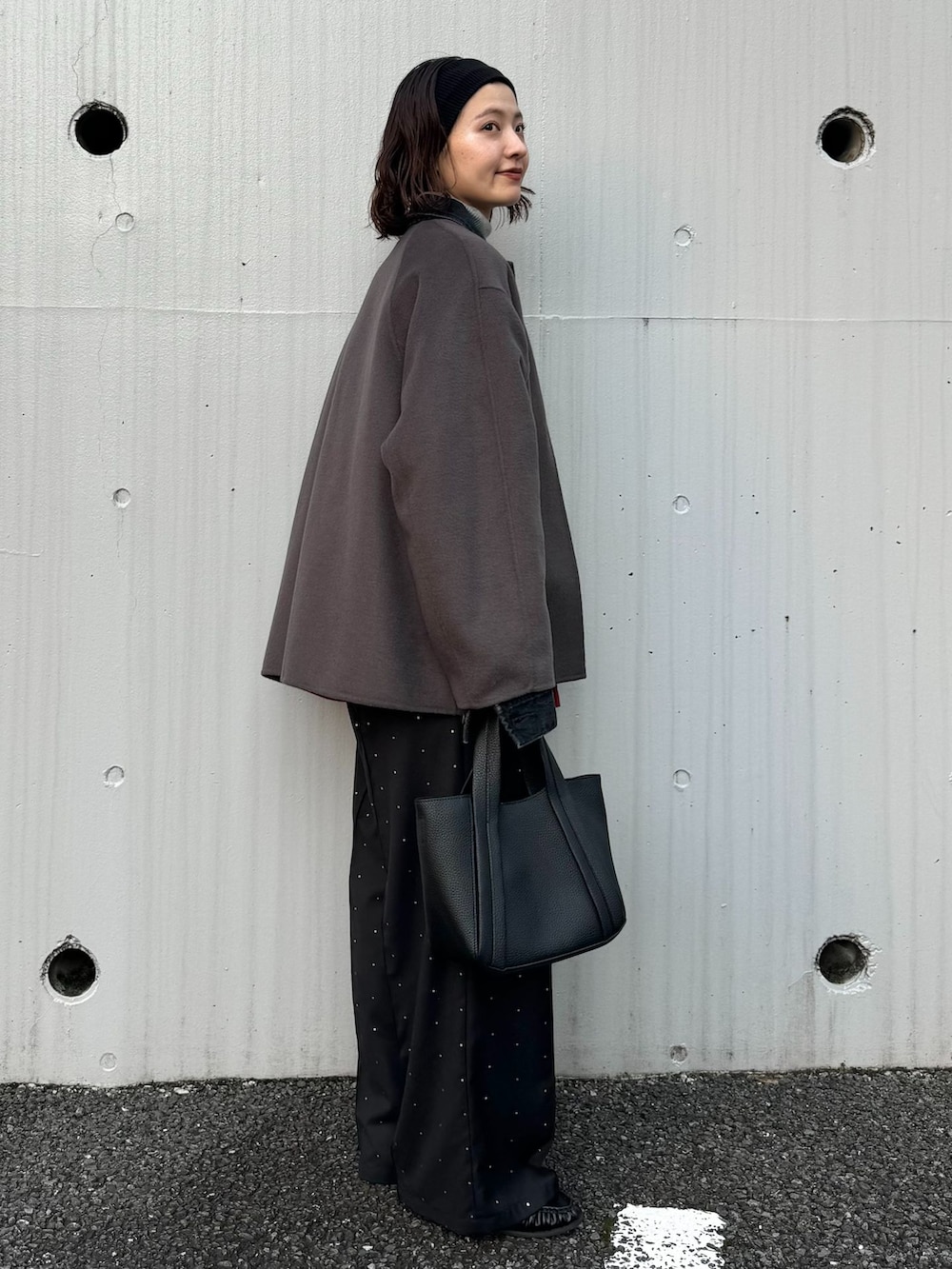 グレー系のノーカラーコート、ブラック系のその他パンツ、グレー系のニット/セーターを着用したレディースの秋コーディネートの2枚目の写真