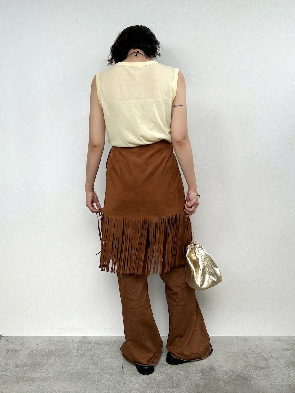 ブラウン系のスカート、イエロー系のトップス、ブラウン系のその他パンツを着用したレディースの夏コーディネートの4枚目の写真