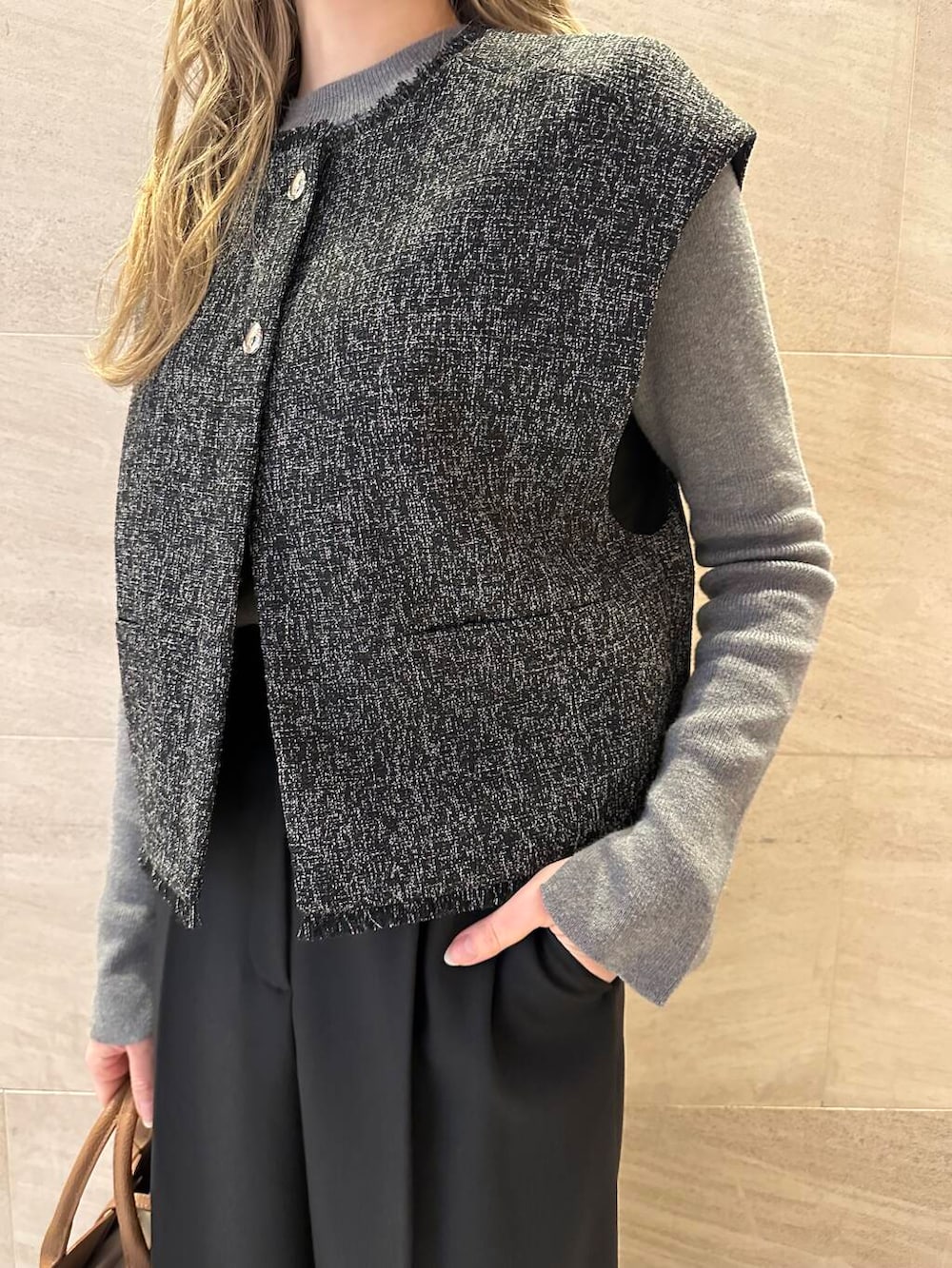 ブラウン系のハンドバッグ、グレー系のニット/セーター、ブラック系のその他パンツを着用したレディースの冬コーディネートの7枚目の写真