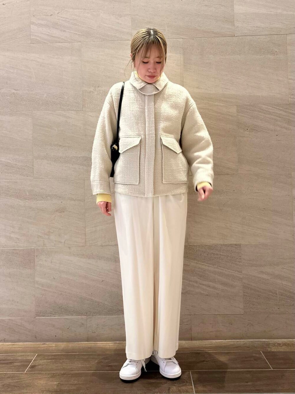 ホワイト系のスニーカー、ホワイト系のブルゾン、ブラック系のショルダーバッグを着用したレディースの冬コーディネートの2枚目の写真