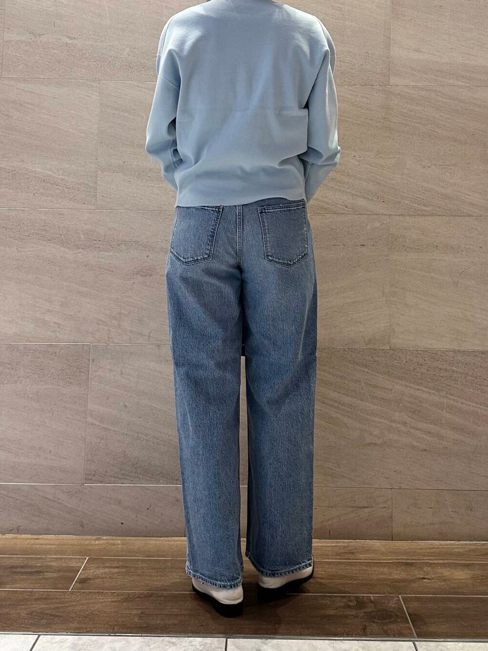 ブルー系のカーディガン/ボレロ、ブルー系のデニムパンツ、ブラウン系のショルダーバッグを着用したレディースの冬コーディネートの4枚目の写真