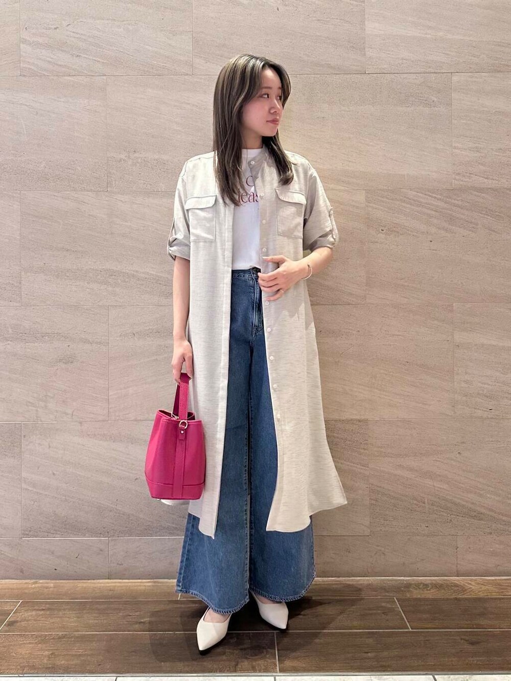 ベージュ系のワンピース、ピンク系のハンドバッグ、ホワイト系のTシャツ/カットソーを着用したレディースの春コーディネートの3枚目の写真