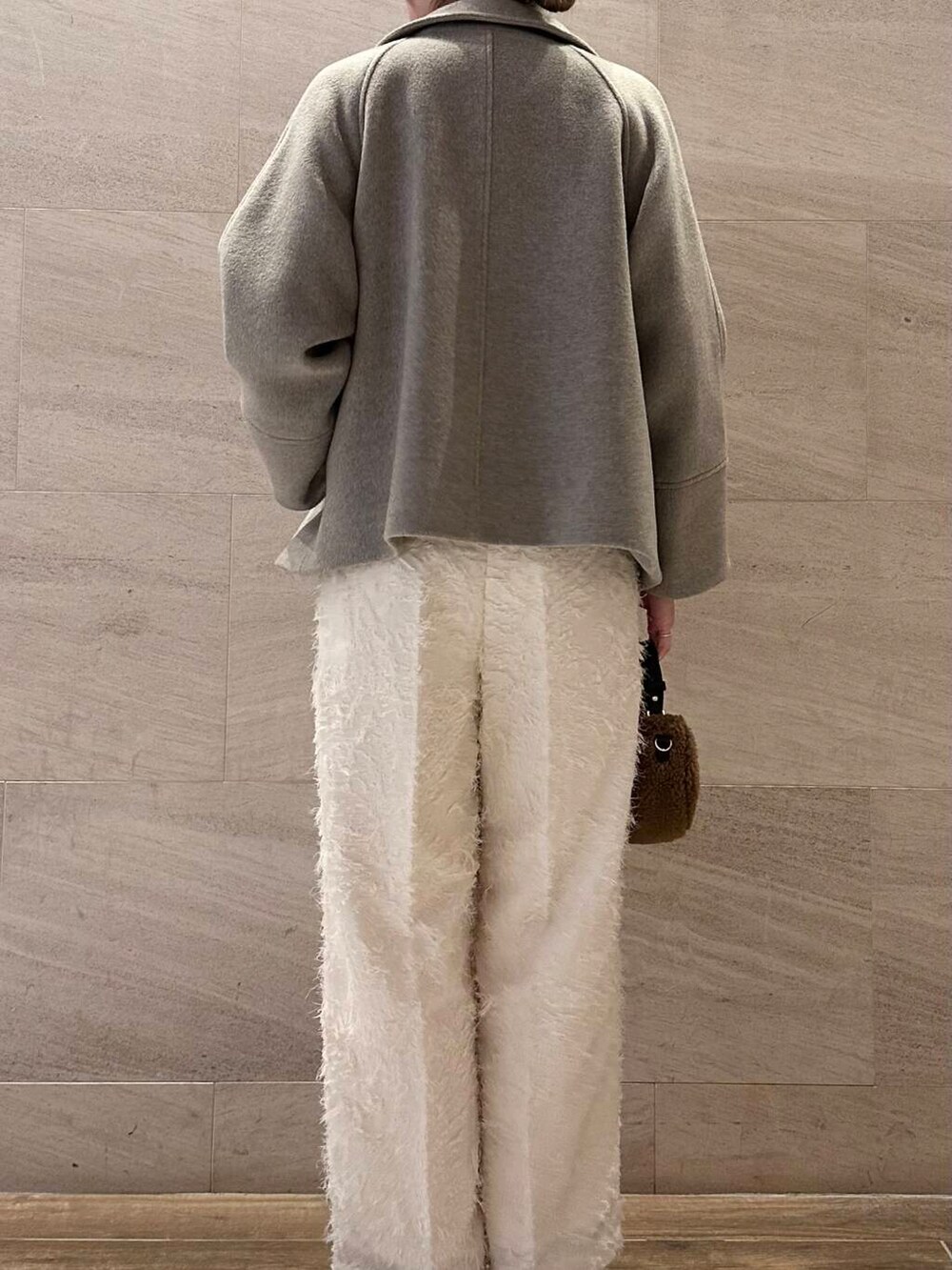 ブラウン系のピーコート、ホワイト系のその他パンツ、ホワイト系のカーディガン/ボレロを着用したレディースの冬コーディネートの4枚目の写真