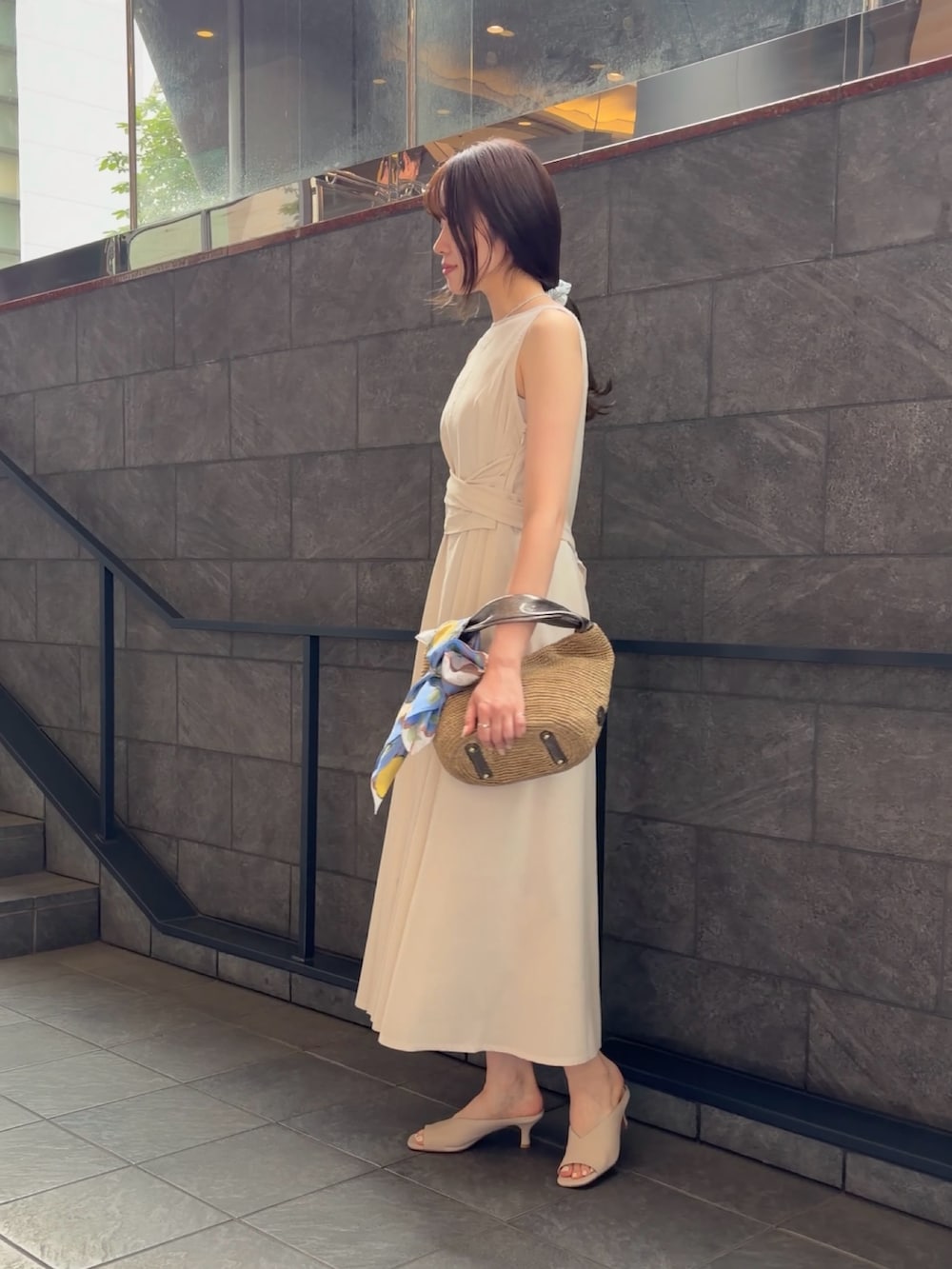 ホワイト系のワンピース、ブラウン系のかごバッグ、ホワイト系のパンプスを着用したレディースの夏コーディネートの2枚目の写真