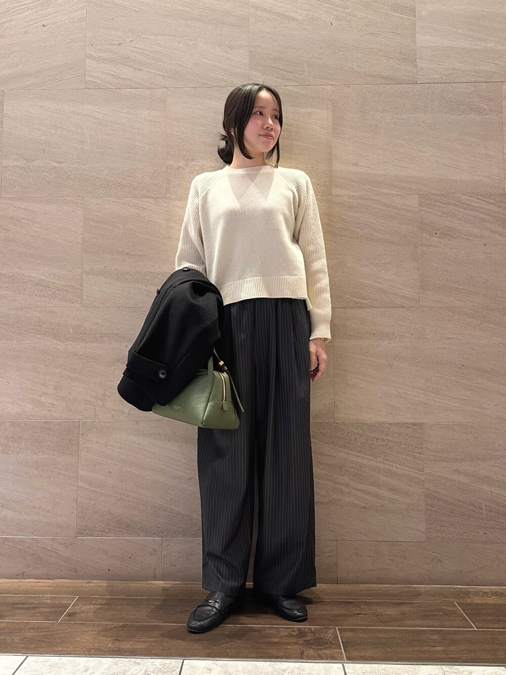ブラック系のステンカラーコート、ホワイト系のニット/セーター、その他のその他パンツを着用したレディースの冬コーディネートの5枚目の写真