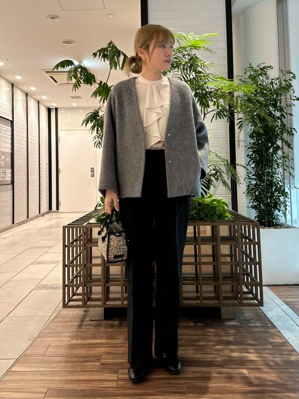 ブラック系のその他パンツ、ホワイト系のシャツ/ブラウス、グレー系のノーカラージャケットを着用したレディースの冬コーディネートの2枚目の写真