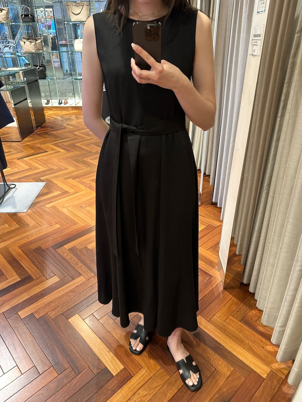 ブラック系のワンピース、ベージュ系のショルダーバッグ、ブラック系のサンダルを着用したレディースの夏コーディネートの4枚目の写真
