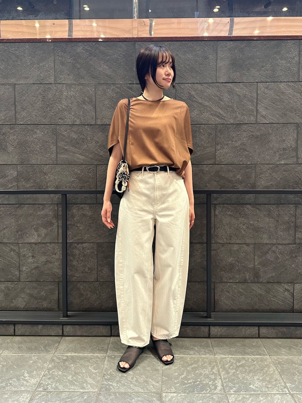 イエロー系のTシャツ/カットソー、ホワイト系のその他パンツ、ブラック系のサンダルを着用したレディースの夏コーディネートの3枚目の写真