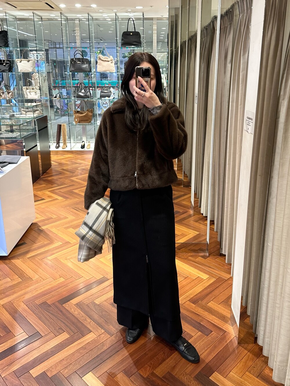ブラウン系のその他アウター、ブラック系のその他パンツ、ブラック系のスカートを着用したレディースの冬コーディネートの5枚目の写真