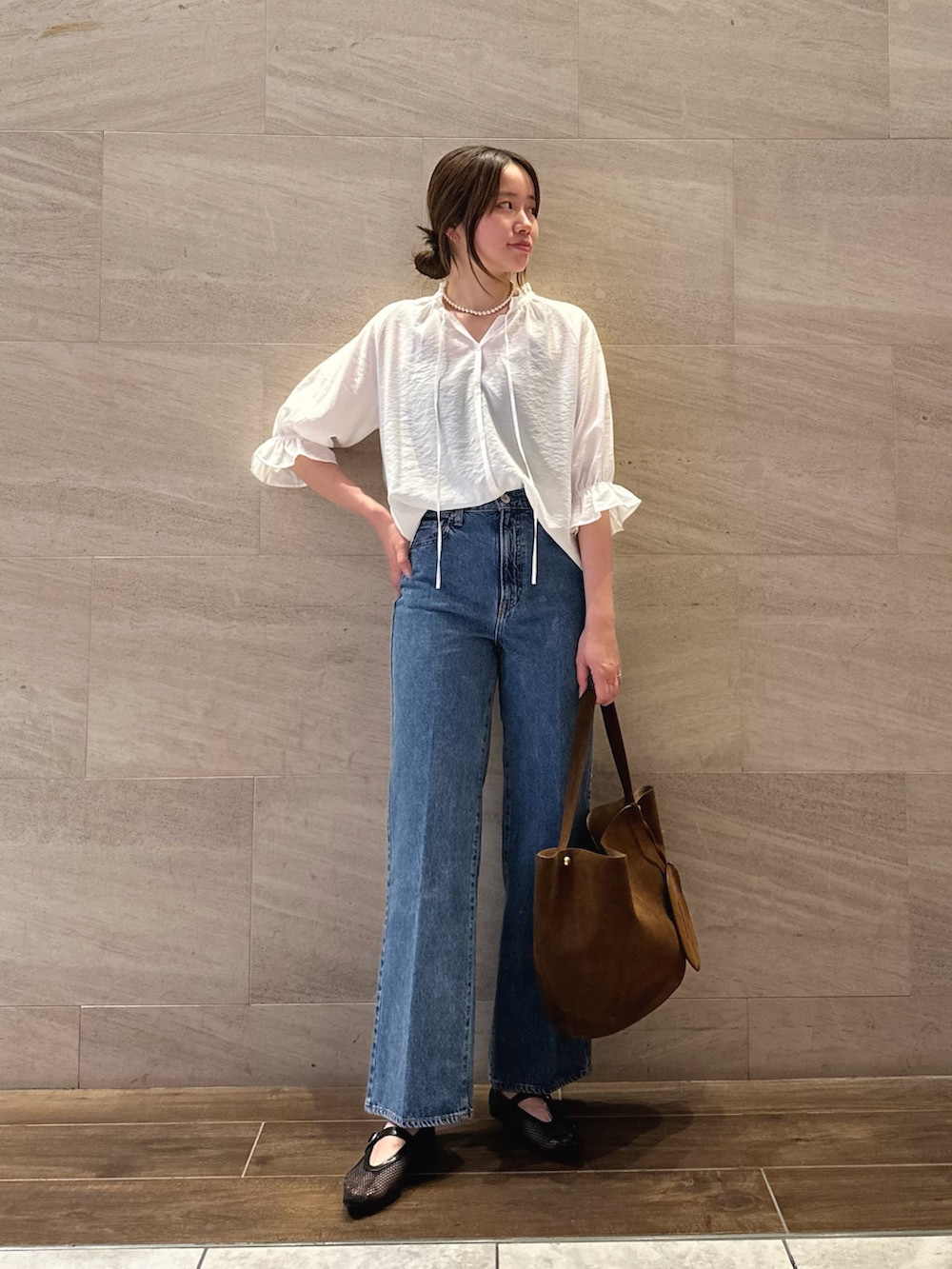 ホワイト系のシャツ/ブラウス、ブルー系のデニムパンツ、ブラウン系のトートバッグを着用したレディースの夏コーディネートの2枚目の写真