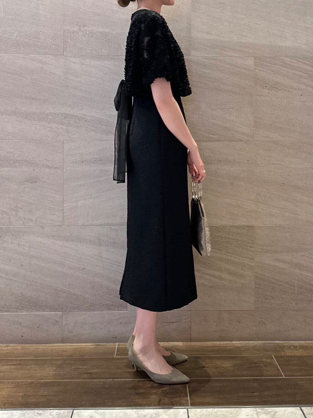 ベージュ系のハンドバッグ、ホワイト系のネックレスを着用したレディースの春コーディネートの4枚目の写真