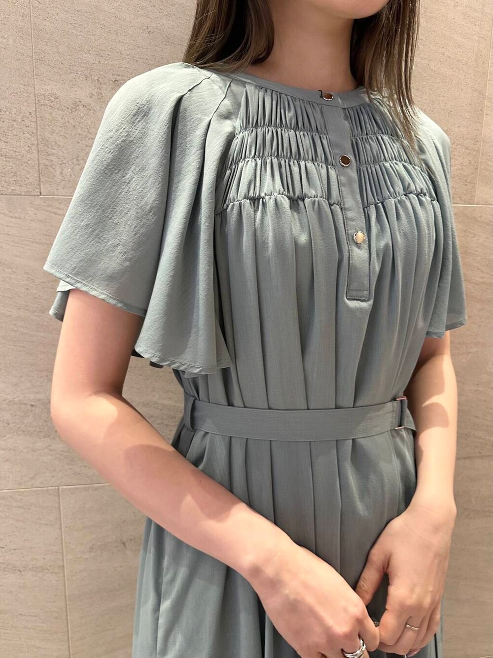 シルバー系のハンドバッグ、ブルー系のワンピース、シルバー系のリングを着用したレディースの夏コーディネートの4枚目の写真