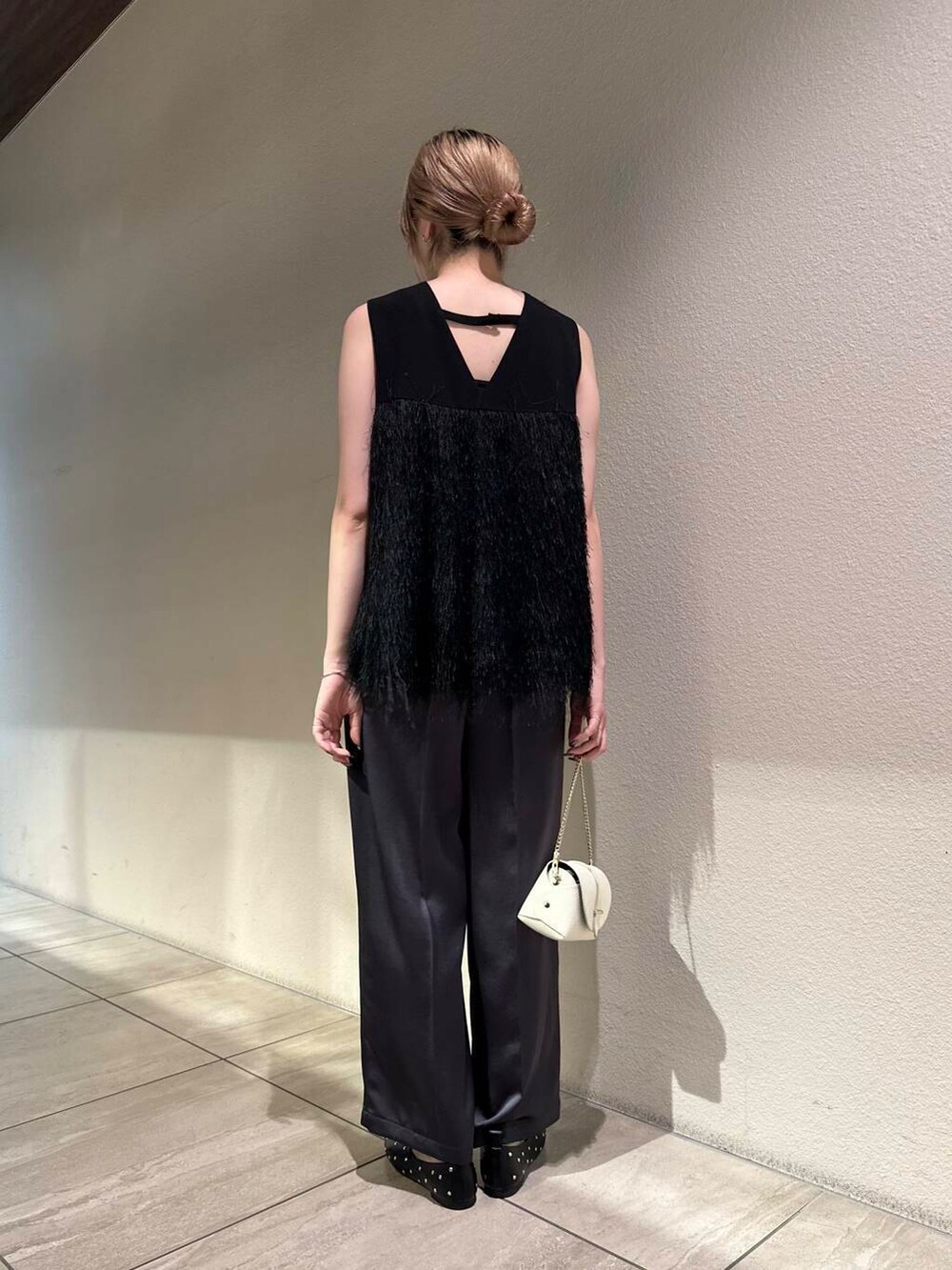 ホワイト系のショルダーバッグ、ブラック系のパンプス、グレー系のその他パンツを着用したレディースの秋コーディネートの4枚目の写真