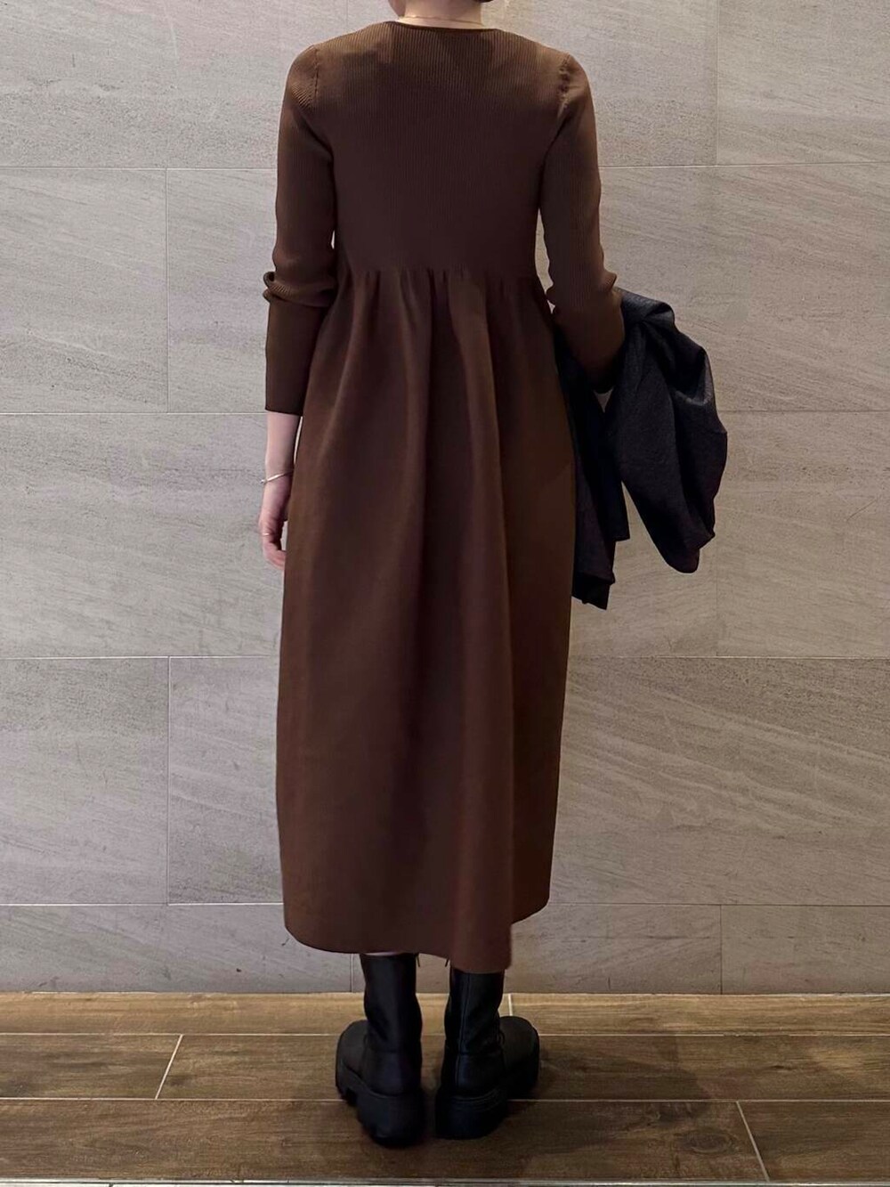 ブラック系のブーツ、ブルー系のその他アウター、ブラウン系のワンピースを着用したレディースの冬コーディネートの7枚目の写真