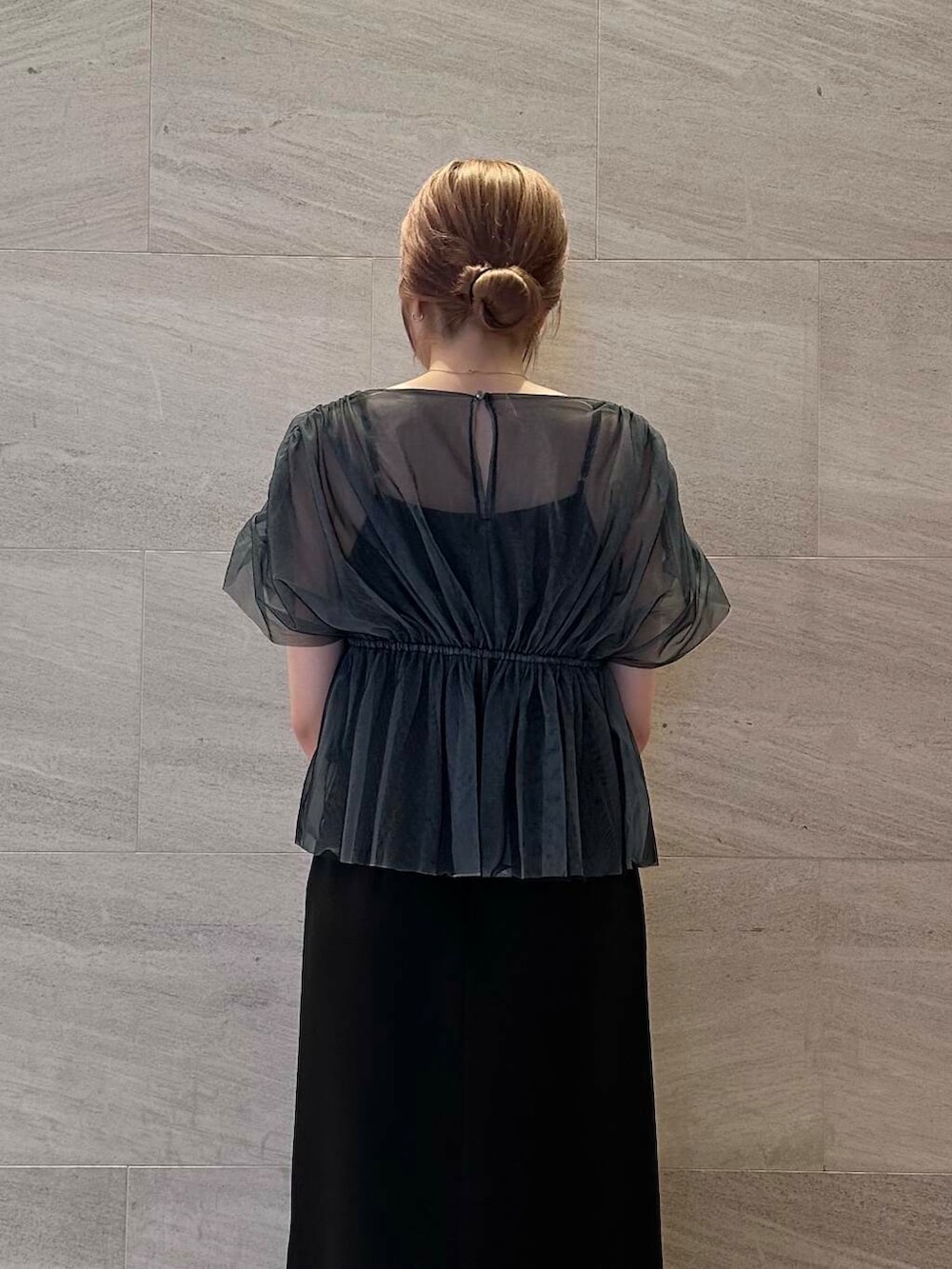 ゴールド系のハンドバッグ、ブラック系のパンプス、ブラック系のワンピースを着用したレディースの夏コーディネートの5枚目の写真