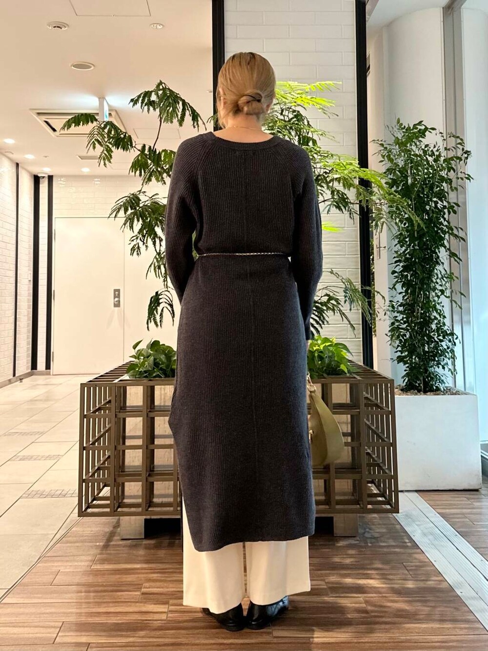 グリーン系のショルダーバッグ、グレー系のワンピース、ホワイト系のその他パンツを着用したレディースの冬コーディネートの5枚目の写真