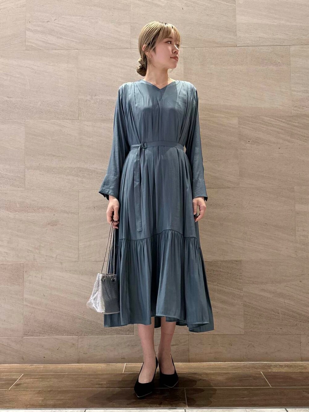 ブラック系のパンプス、ブルー系のワンピース、シルバー系のショルダーバッグを着用したレディースの冬コーディネートの5枚目の写真