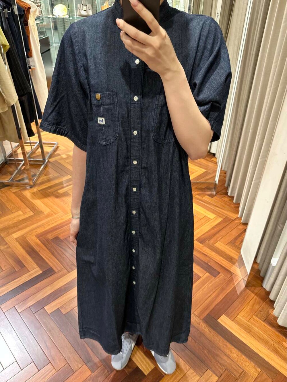 ブラウン系のかごバッグ、ブルー系のワンピース、グレー系のスニーカーを着用したレディースの夏コーディネートの6枚目の写真