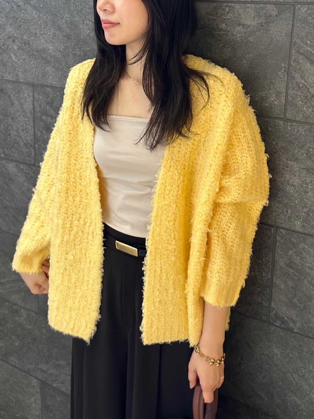 イエロー系のカーディガン/ボレロ、グレー系のその他パンツ、ベージュ系のキャミソールを着用したレディースの秋コーディネートの5枚目の写真