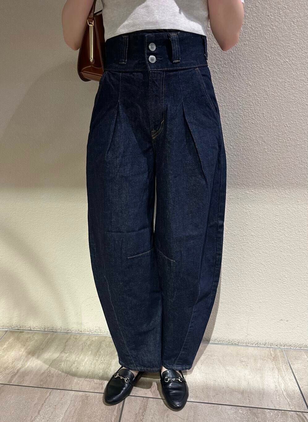 ブラック系のローファー、ホワイト系のニット/セーター、ブルー系のデニムパンツを着用したレディースの秋コーディネートの7枚目の写真