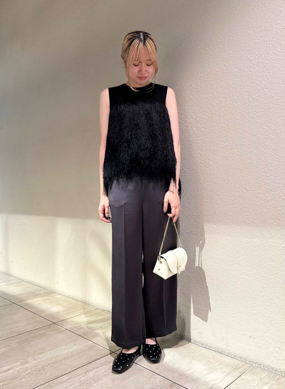 ホワイト系のショルダーバッグ、ブラック系のパンプス、グレー系のその他パンツを着用したレディースの秋コーディネートの3枚目の写真