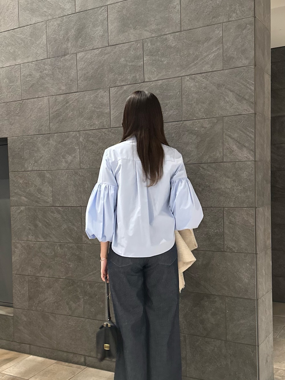ブルー系のシャツ/ブラウス、ブルー系のデニムパンツ、ベージュ系のベストを着用したレディースの冬コーディネートの4枚目の写真