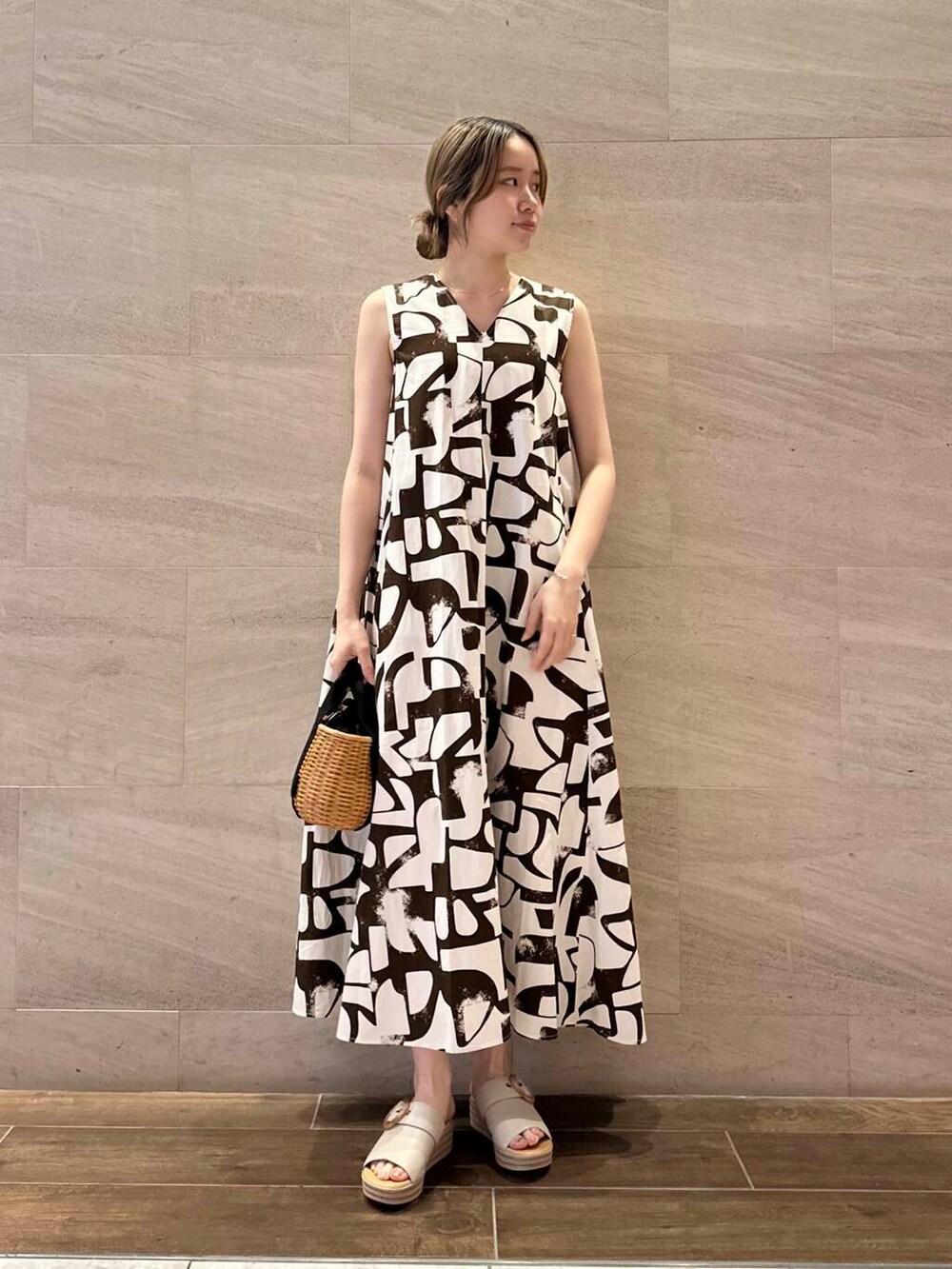 ブラック系のハンドバッグ、ブラック系のカーディガン/ボレロ、ブラウン系のワンピースを着用したレディースの春コーディネートの5枚目の写真