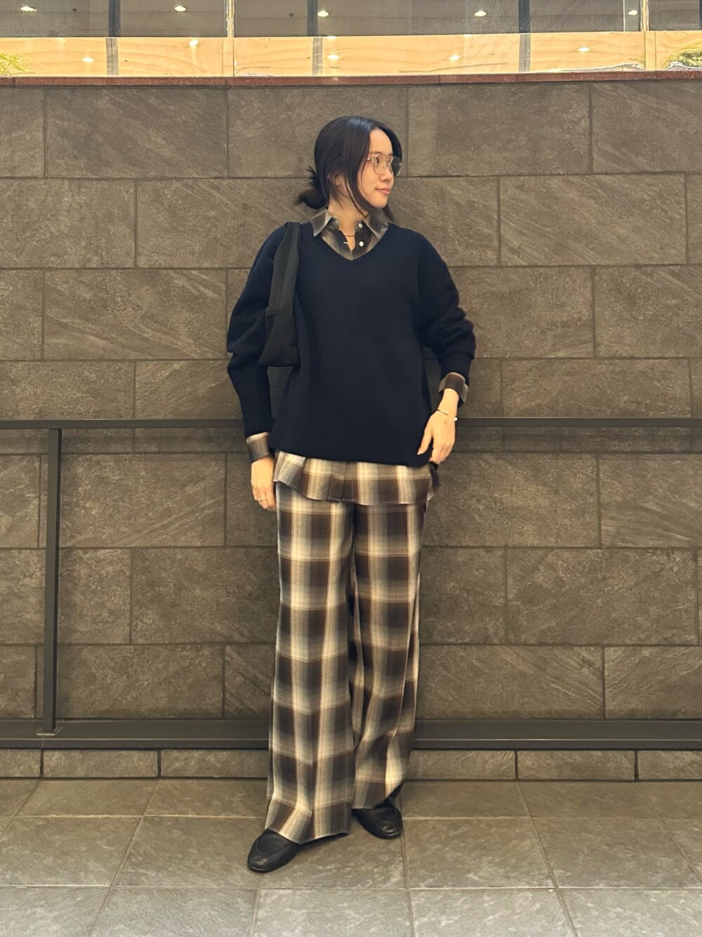 ブラック系のハンドバッグ、ブルー系のシャツ/ブラウス、ブルー系のスラックスを着用したレディースの秋コーディネートの3枚目の写真