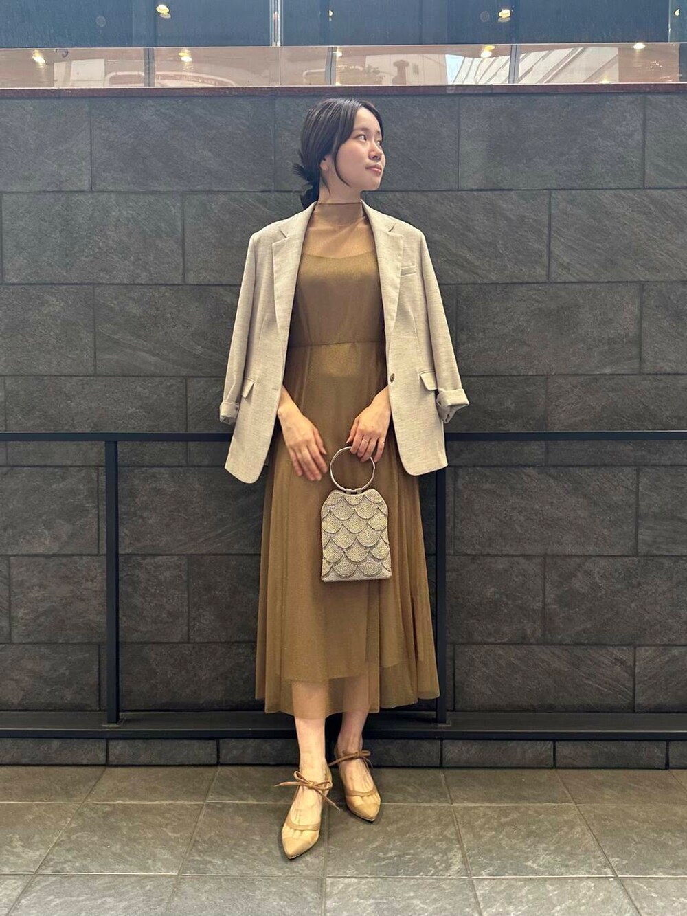 ゴールド系のワンピース、ベージュ系のハンドバッグ、ベージュ系のその他アウターを着用したレディースの夏コーディネートの4枚目の写真