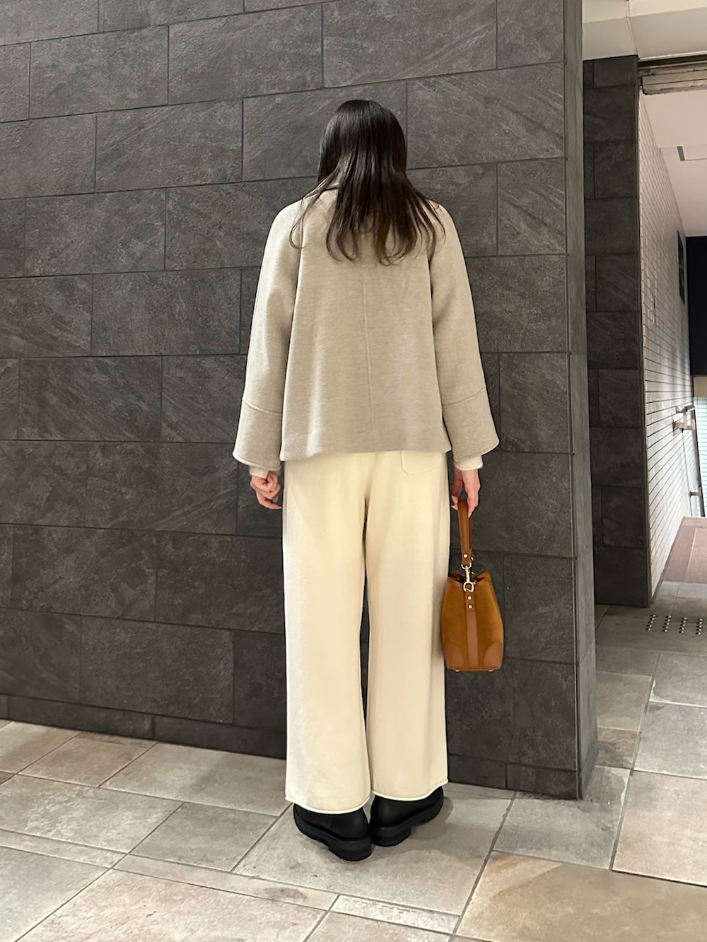 ホワイト系のカーディガン/ボレロ、ホワイト系のその他パンツ、ブラウン系のハンドバッグを着用したレディースの冬コーディネートの2枚目の写真