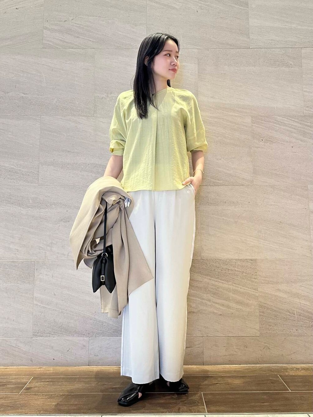 イエロー系のシャツ/ブラウス、ベージュ系のトレンチコート、ベージュ系のその他パンツを着用したレディースの春コーディネートの7枚目の写真