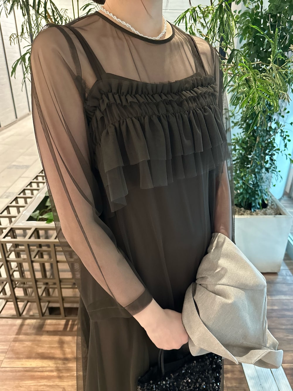 ベージュ系のその他アウター、ブラウン系のワンピース、ブラック系のハンドバッグを着用したレディースの春コーディネートの4枚目の写真