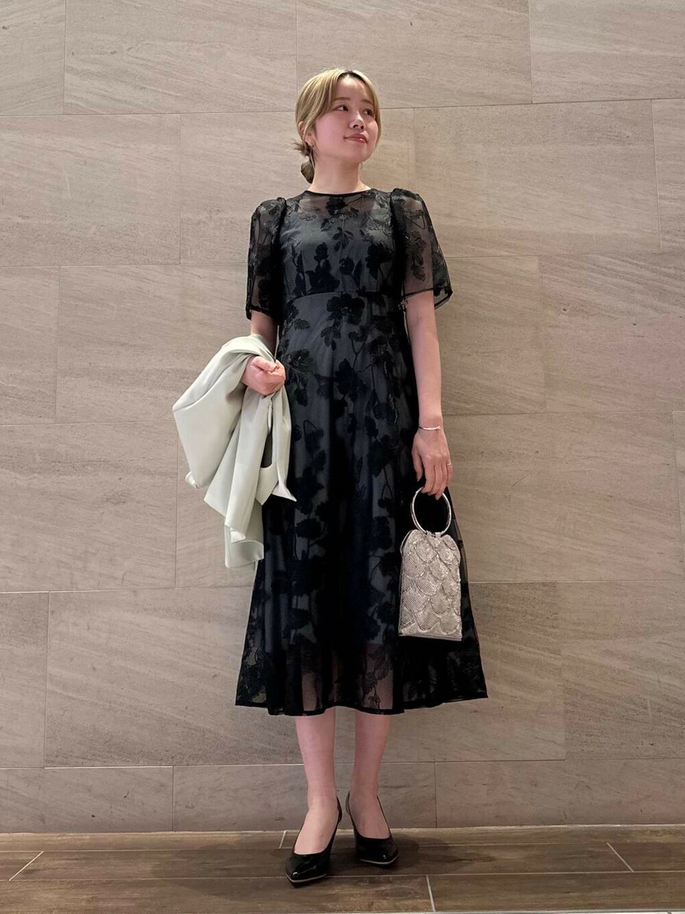 ブラック系のパンプス、シルバー系のハンドバッグ、イエロー系のその他アウターを着用したレディースの春コーディネートの6枚目の写真